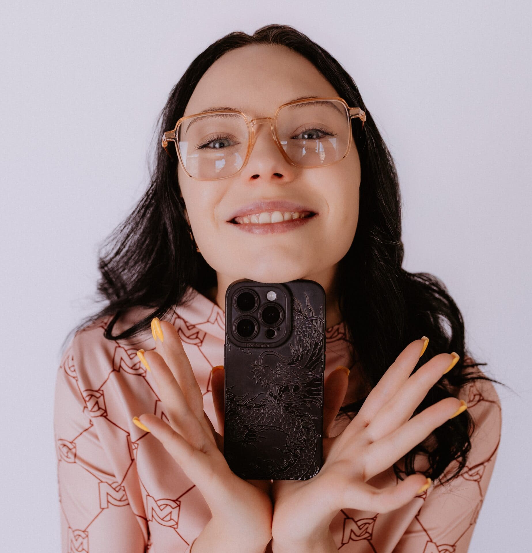 Sperdd, meitene ar brillēm un telefonu, jaunās tehnoloģijas un modes apvienojums, moderns un stilīgs ikdienas izskats, kamera uzņemtā bilde.