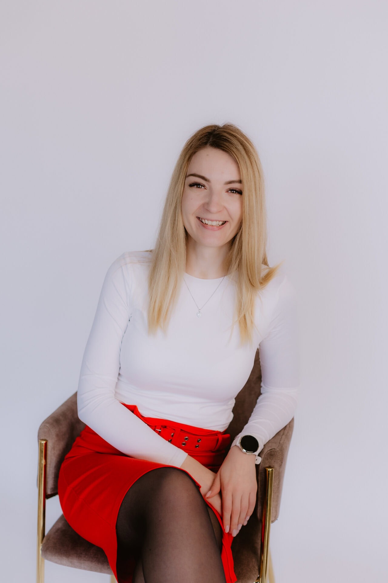 Smarža sieviete smaidot un sēžot krēklā, baltā t-kreklā un sarkanā kreklā, moderns portrets.