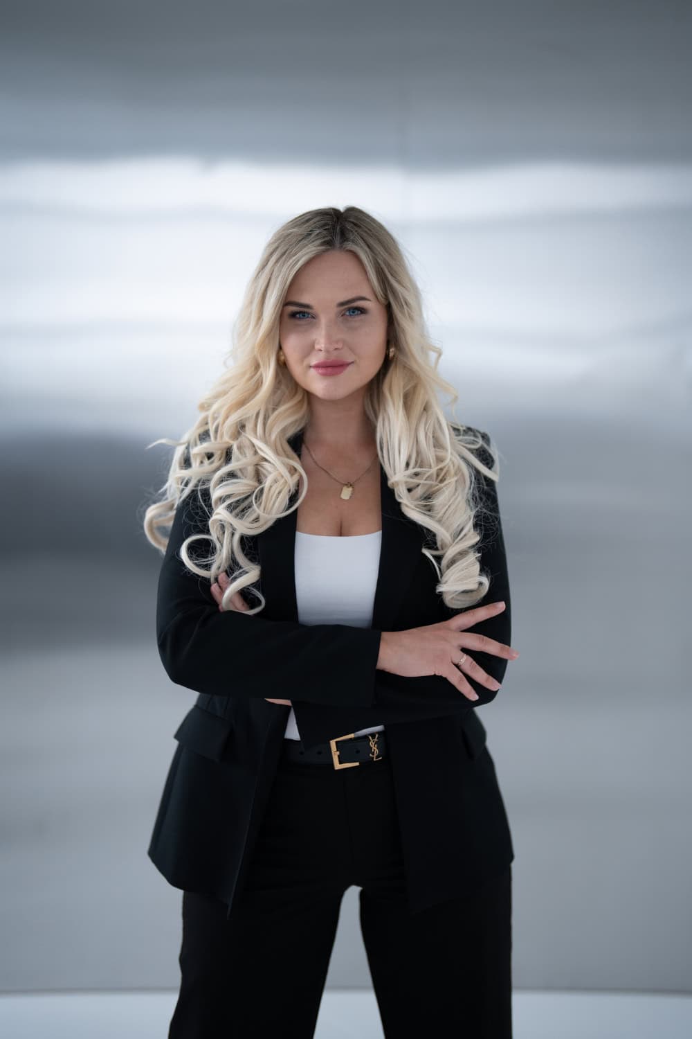 1. Stilīga biznesa sieviete ar blondiem viļņainiem matiem, nodrošina profesionālu izskatu.